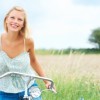 It begins with getting in touch with who you are and all that you have to offer. A beautiful woman is riding a bike in a field living life to the fullest.